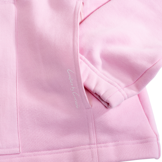 Close-up of a pink jacket with a brand logo on the sleeve.